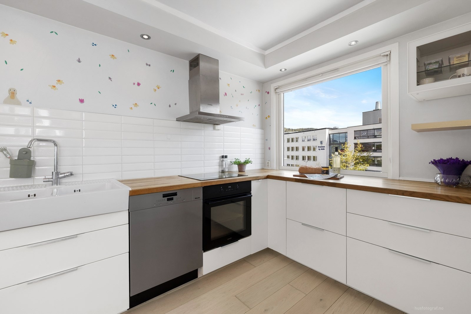 Moderne kjøkkeninnredning med slette fronter, utstyrt med stekeovn og platetopp. Galleribilde
