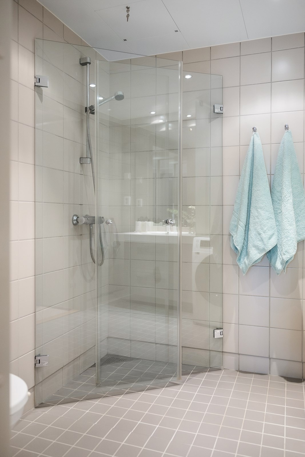 Badet har gulvvarme, downlights, vegghengt toalett, servant med skuffer under samt dusjhjørne med innadslående glassdører. Galleribilde