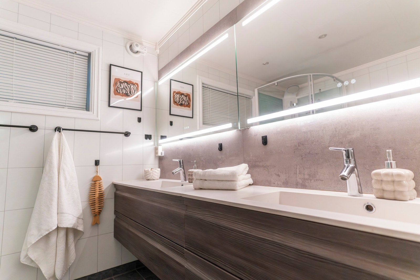 Badet har flislagt gulv med varmekabler. Innredningen med heldekkende servant og to kummer ble montert i 2020. Galleribilde