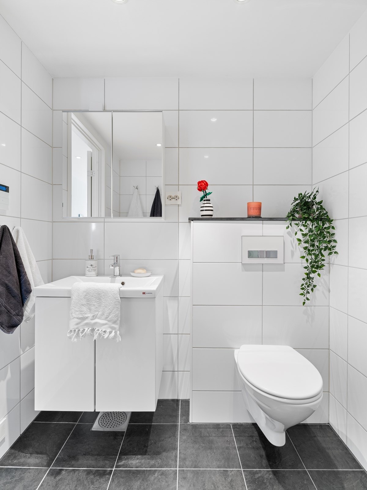 Badet er innredet med vegghengt toalett og baderomsmøbel med servant. Galleribilde