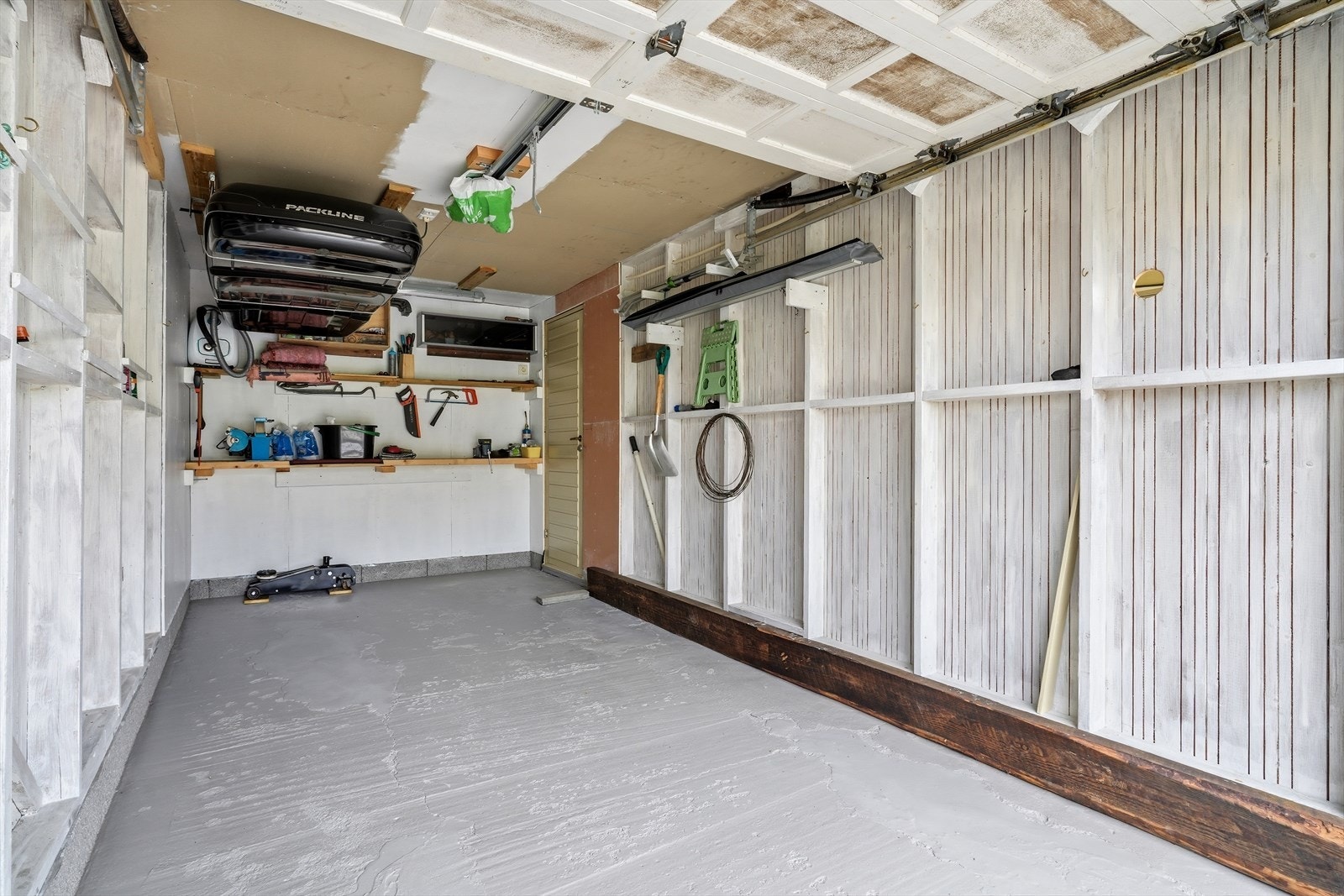 Garasje fra 1988 med støpt plate og vegger i bindingsverk. Det er også en carport inntil garasjen. Galleribilde