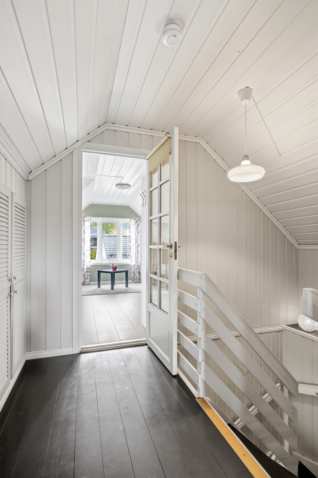 Trapperommet på loftet har malte furugulv og dør med glassfelt inn til loftstue/soverom. Galleribilde