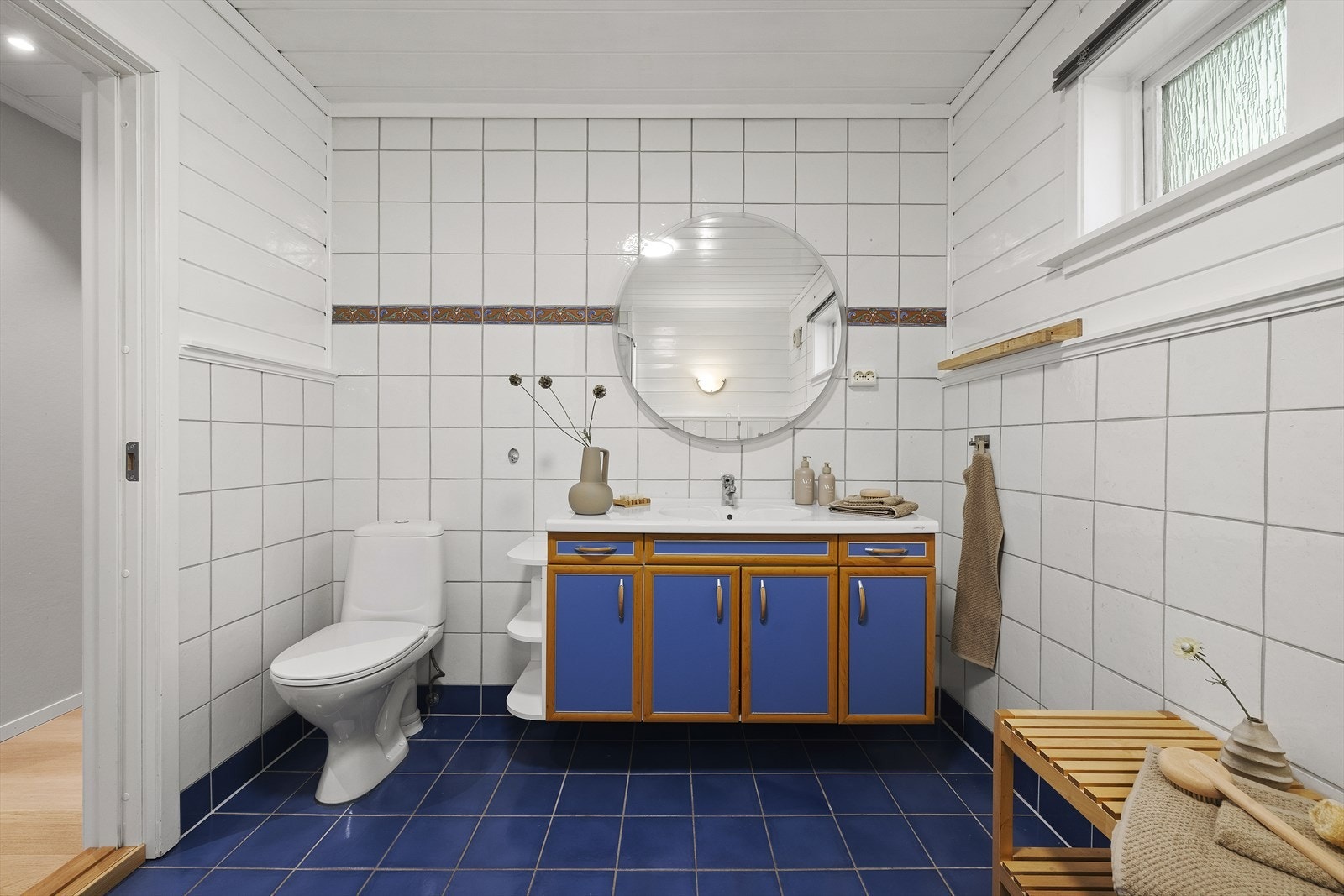 Hovedbadet har delvis flis på vegger og gulv, med varmekabler Galleribilde