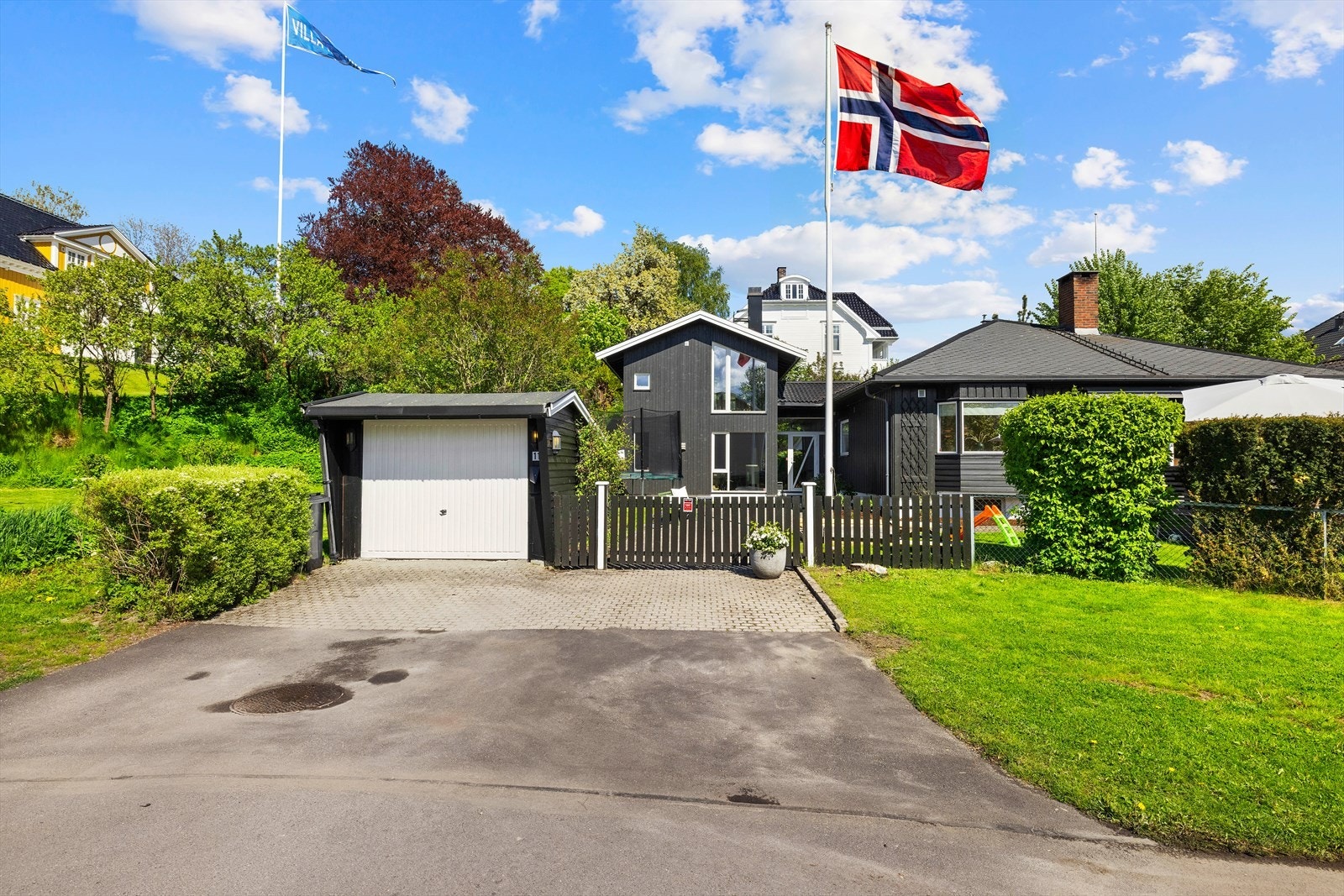 I tomtegrenser er det gjerde og vegetasjon som skjermer godt for innsyn og utgjør en pen ramme rundt denne flotte boligen Galleribilde