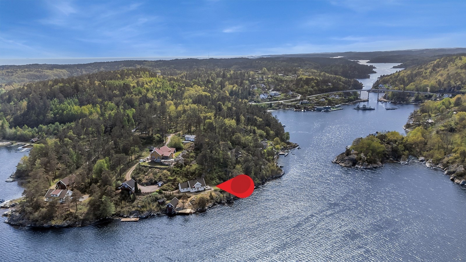 Eiendommen består av en enebolig, garasjebygning og et båthus med egen brygge, alt plassert i vannkanten. Galleribilde