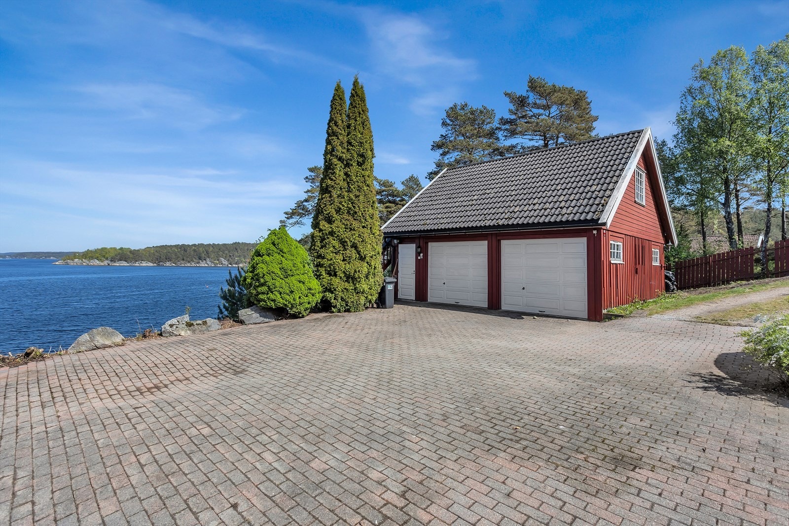 Garasjen har to porter og en stor, steinbelagt gårdsplass. Galleribilde