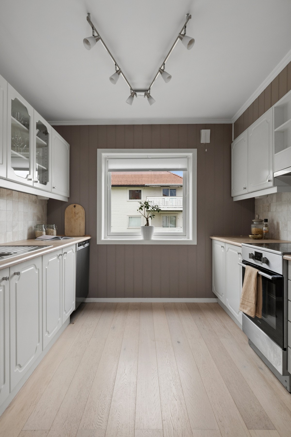 Kjøkken med profilerte fronter, heltre benkeplate og fliser over benk. Opplegg for oppvaskmaskin og ventilator med utlufting. Galleribilde