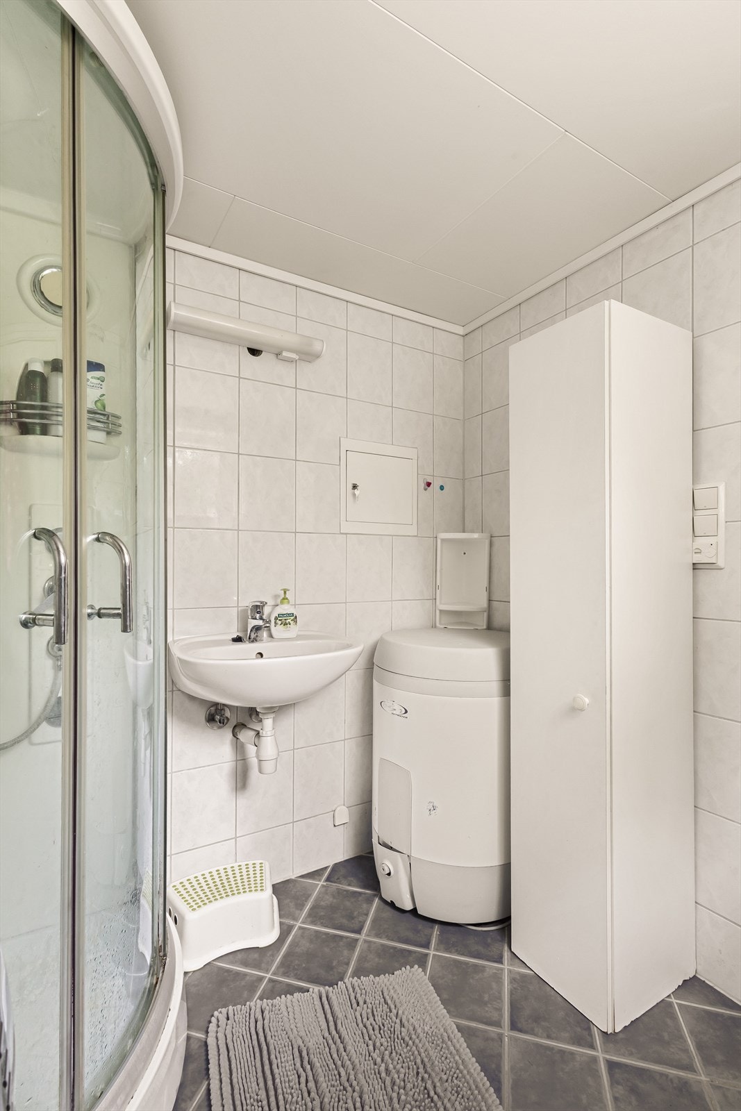 Badet inneholder servant, dusjkabinett og opplegg for vaskemaskin. Galleribilde