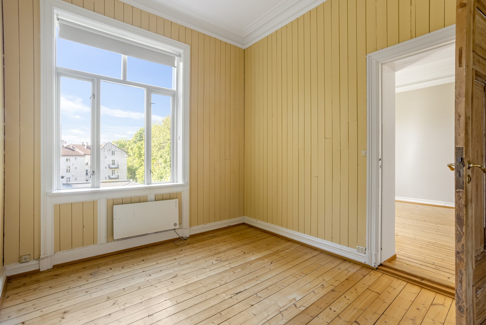 Lyst og romslig soverom med god takhøyde, originale tregulv og klassiske detaljer som stukkatur og brede listverk. Galleribilde