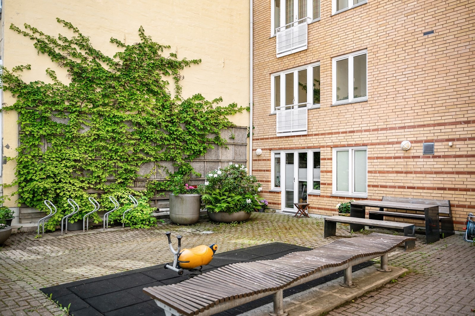 Et skjermet gårdsrom med sykkelparkering og beplantning. Galleribilde