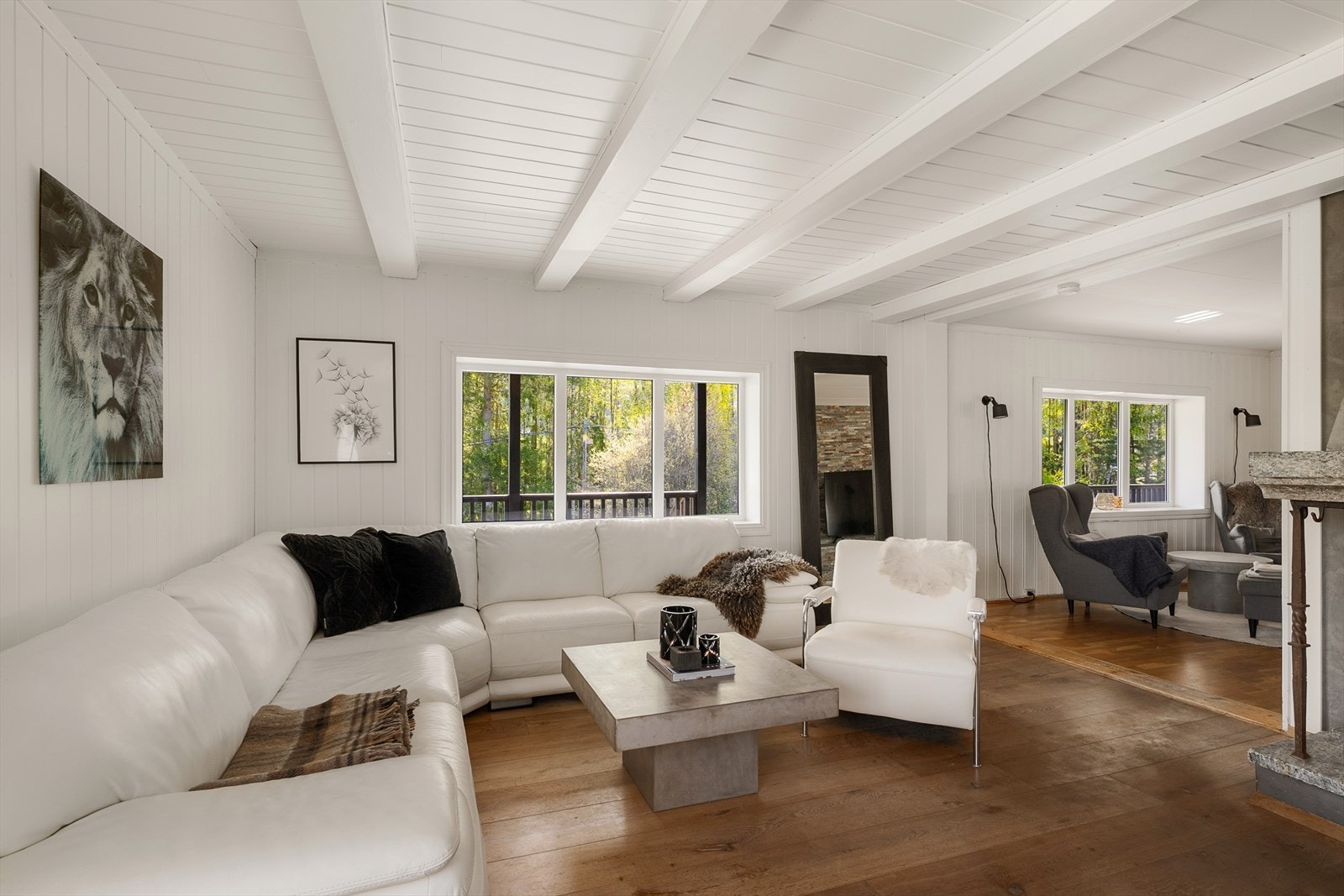 Rommet har parkett på gulv og malt panel i himling med synlige bjelker. Galleribilde