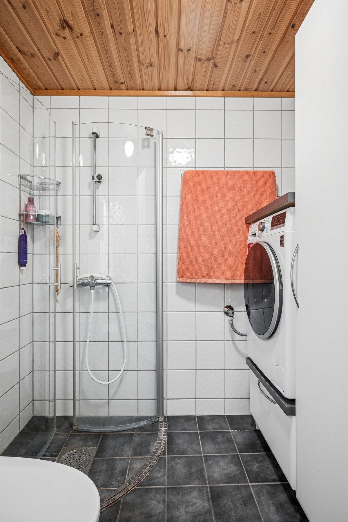 Badet har flislagt gulv med gulvvarme, dusjhjørne med svingdører og opplegg for vaskemaskin. Galleribilde