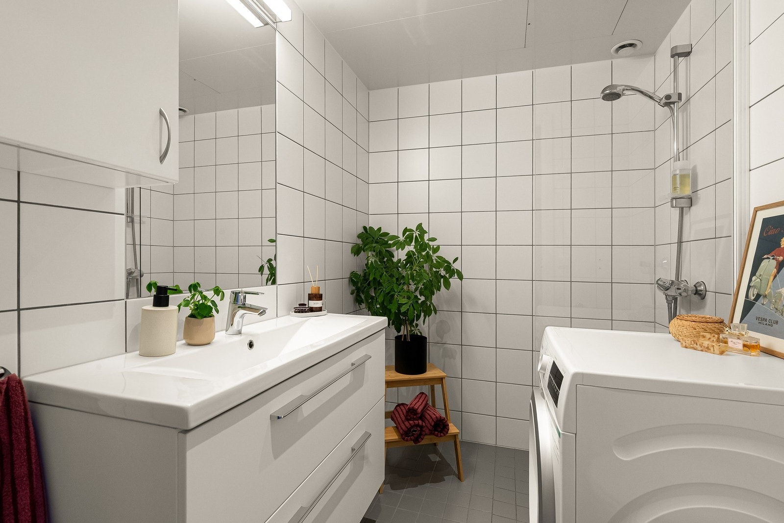 Innbydende og tidløst baderom med termostatstyrte varmekabler i gulv, dusjhjørne med sluk og termostatstyrt blandebatteri, samt opplegg for vaskemaskin og tørketrommel. Galleribilde