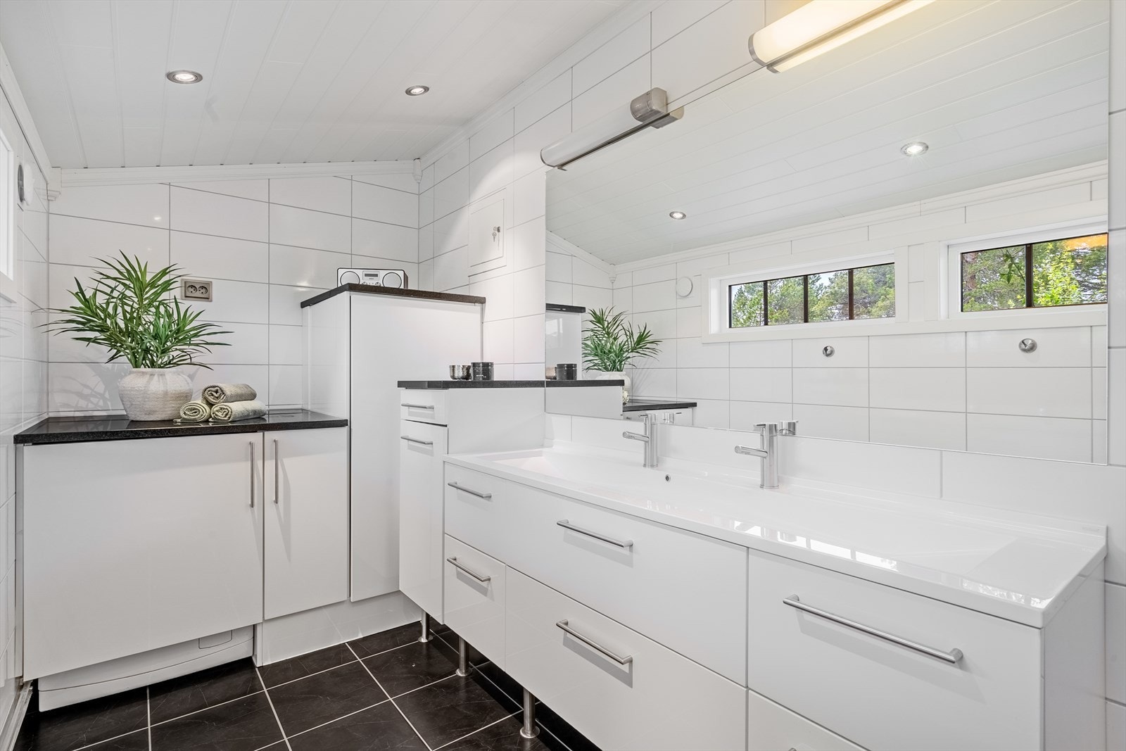 Badet er innredet med WC, romslig dusjsone og baderomsinnredning med dobbel servant og godt med skuffeoppbevaring. Galleribilde