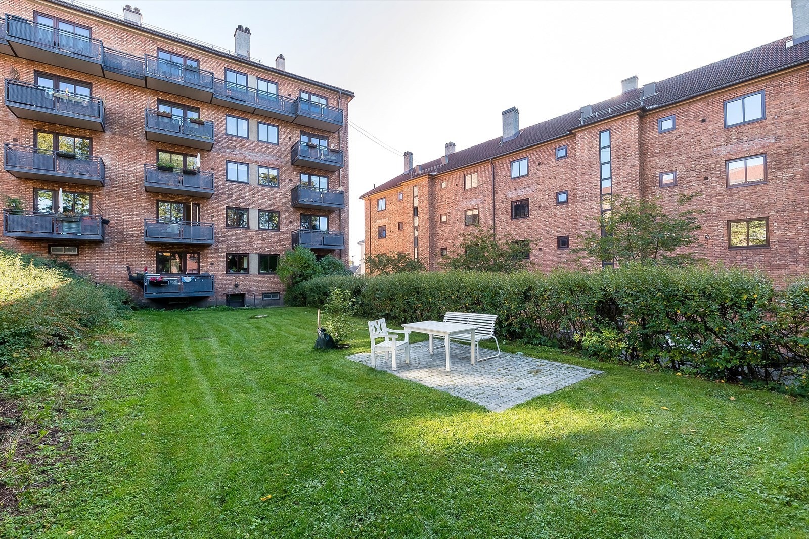 Hyggelig bakgård med gressplen og sittegruppe for beboerne. Galleribilde