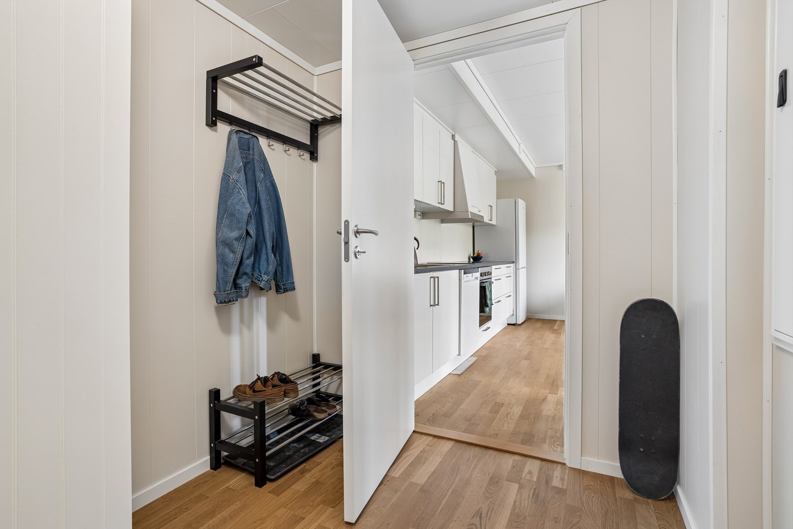 Entré med parkett på gulv og vegger kledd med smartpanel, som er gjennomgående i leiligheten. Galleribilde