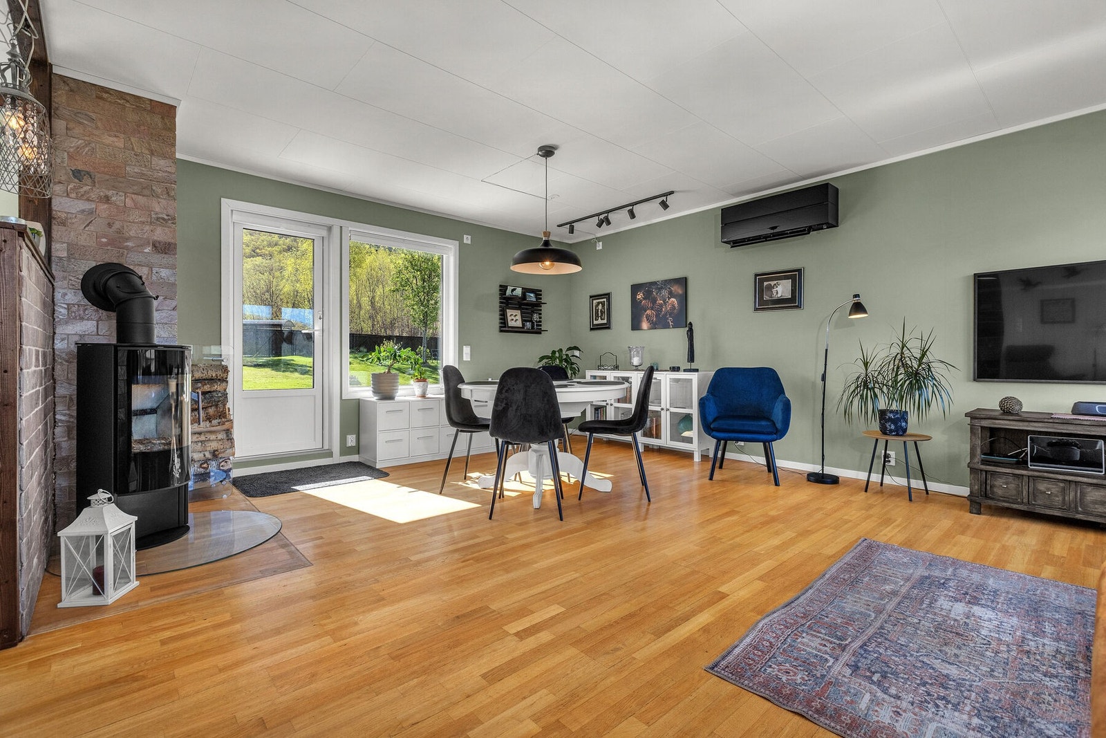Vedovnen gir ekstra varme og en hyggelig atmosfære. Fra spisestuen er det også utgang til verandaen på baksiden av huset. Galleribilde