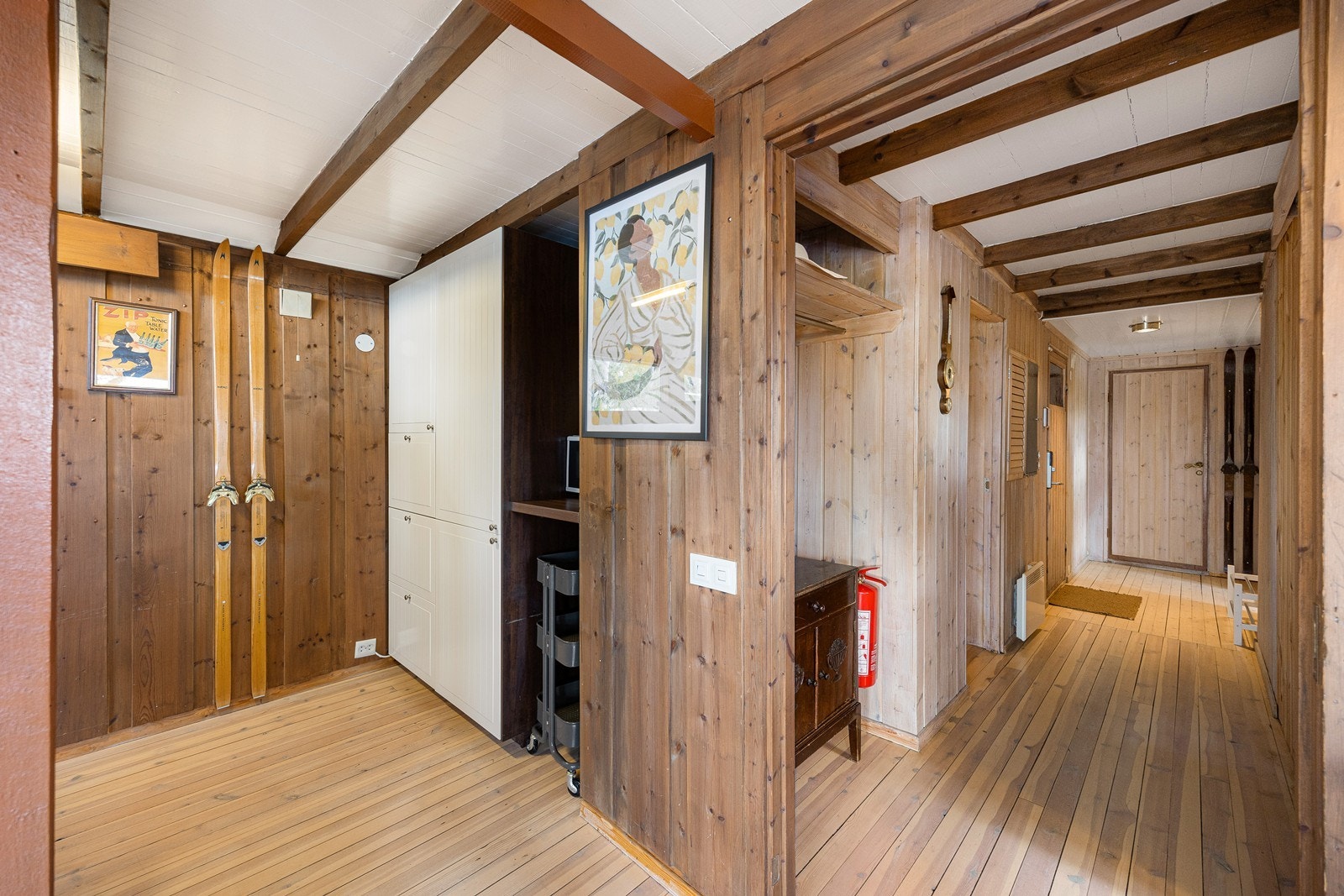 Hytta har adkomst via et åpent, overbygd vindfang og ytterdør med kodelås, til en gang med plass til garderobeløsning. Galleribilde