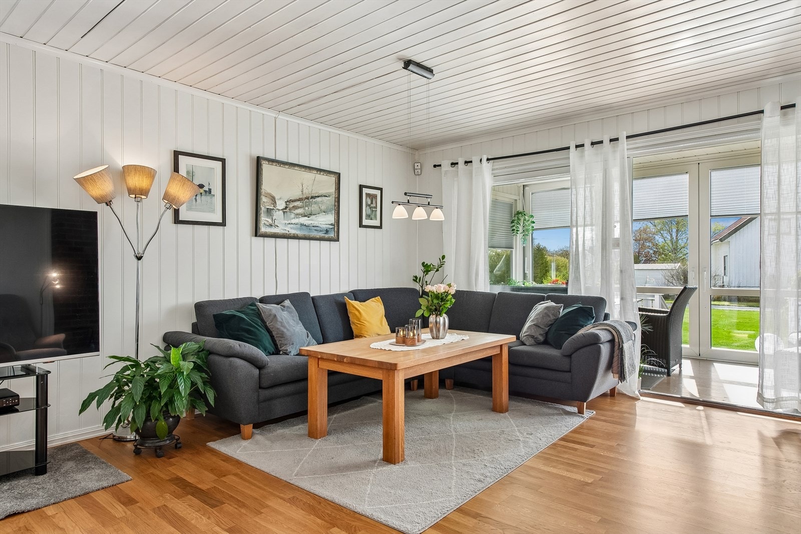 Fra stuen er det utgang til en innglasset terrasse, hagen og en stor terrasseplatting Galleribilde