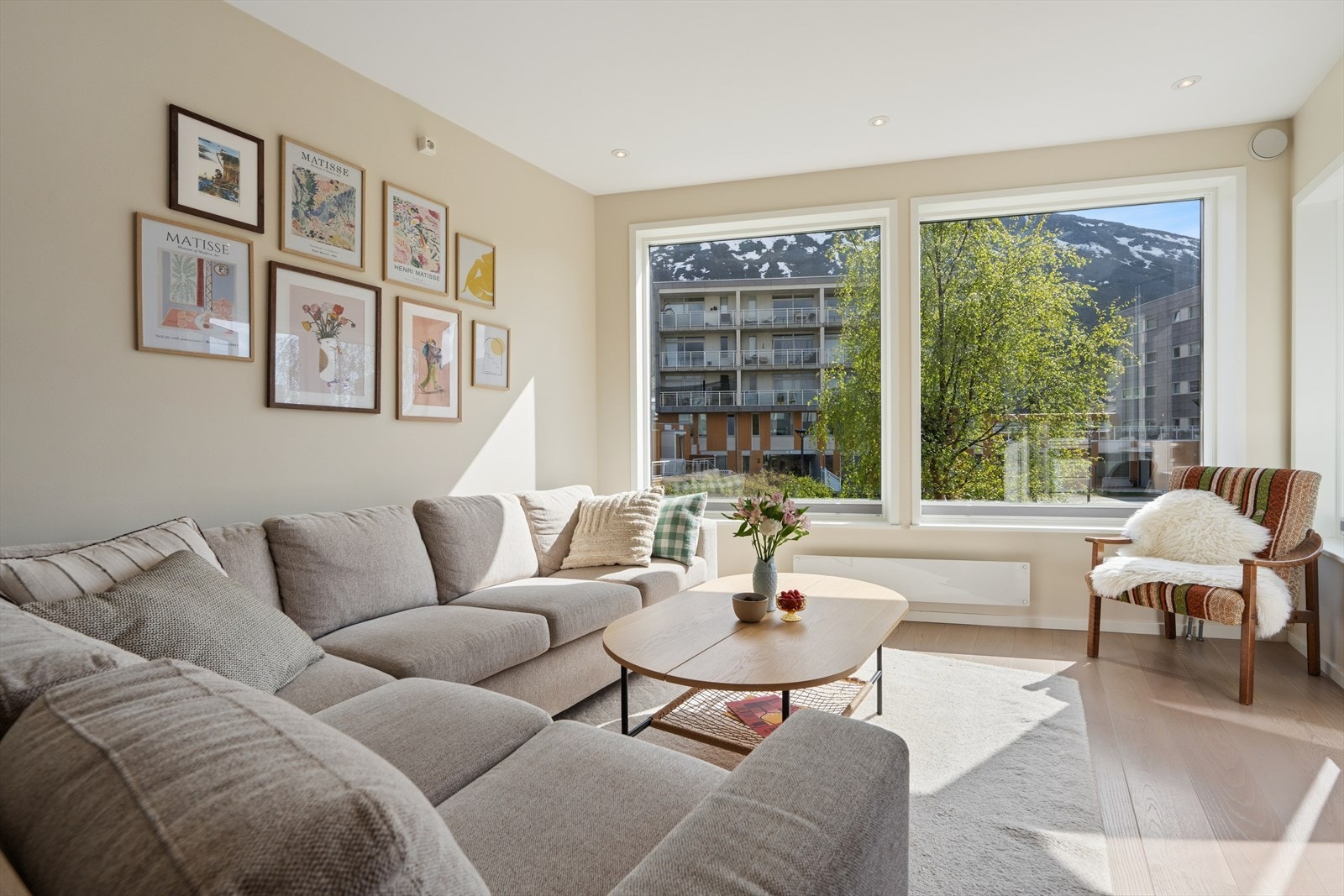 Stuen har store vindusflater som gir rikelig med naturlig lys inn og hyggelig utsyn mot hage og fellesareal. Galleribilde