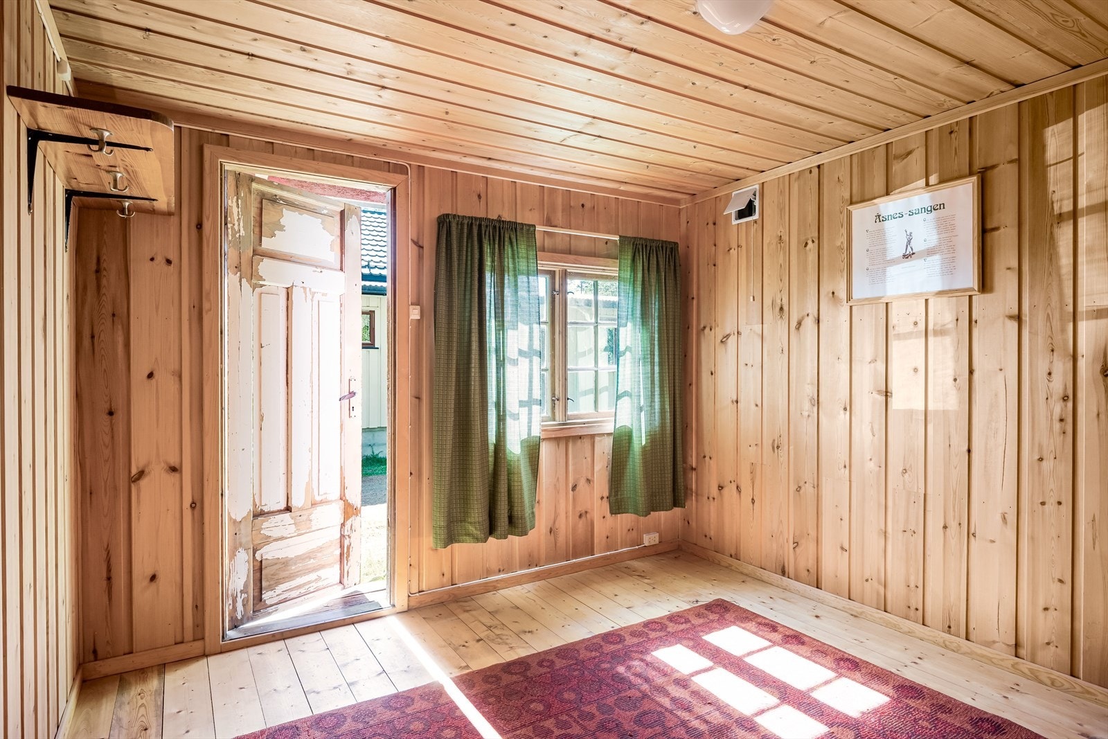 Ett rom med trepanel på vegger og tak, og tregulv. Galleribilde