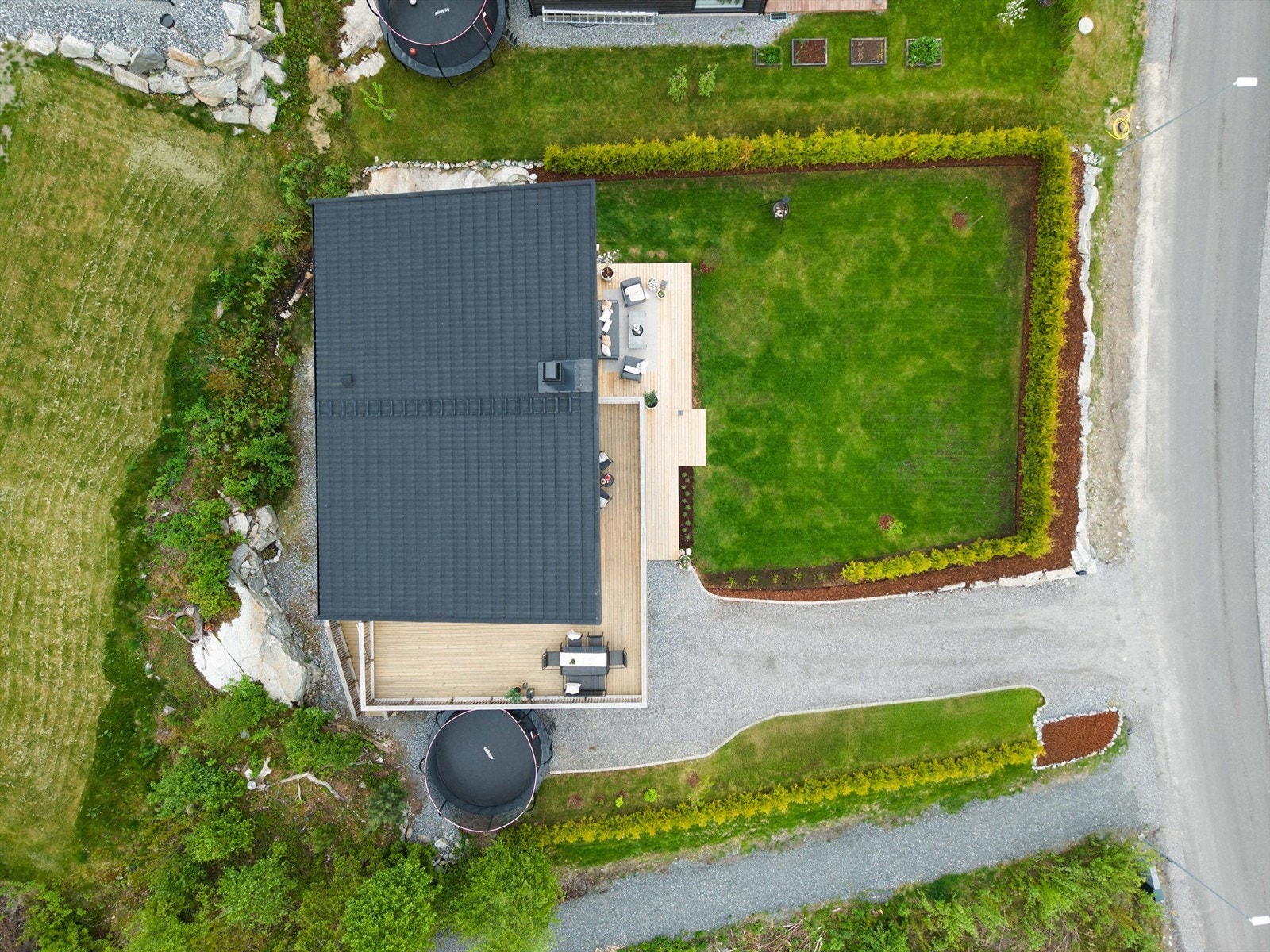 Tomten er pent opparbeidet med plen og hekk. Carporten er utstyrt med ladeboks for elbil. Galleribilde