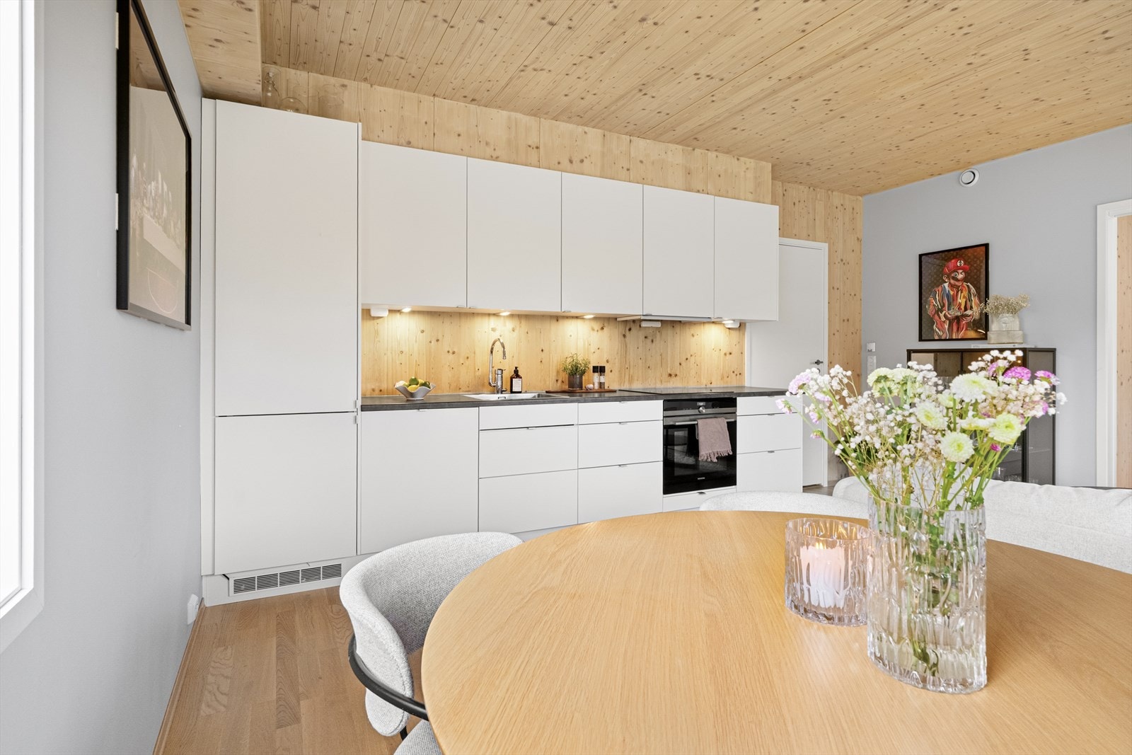 Tidløst og moderne kjøkkeninnredning med hvite, slette fronter og benkeplate av laminat. Galleribilde