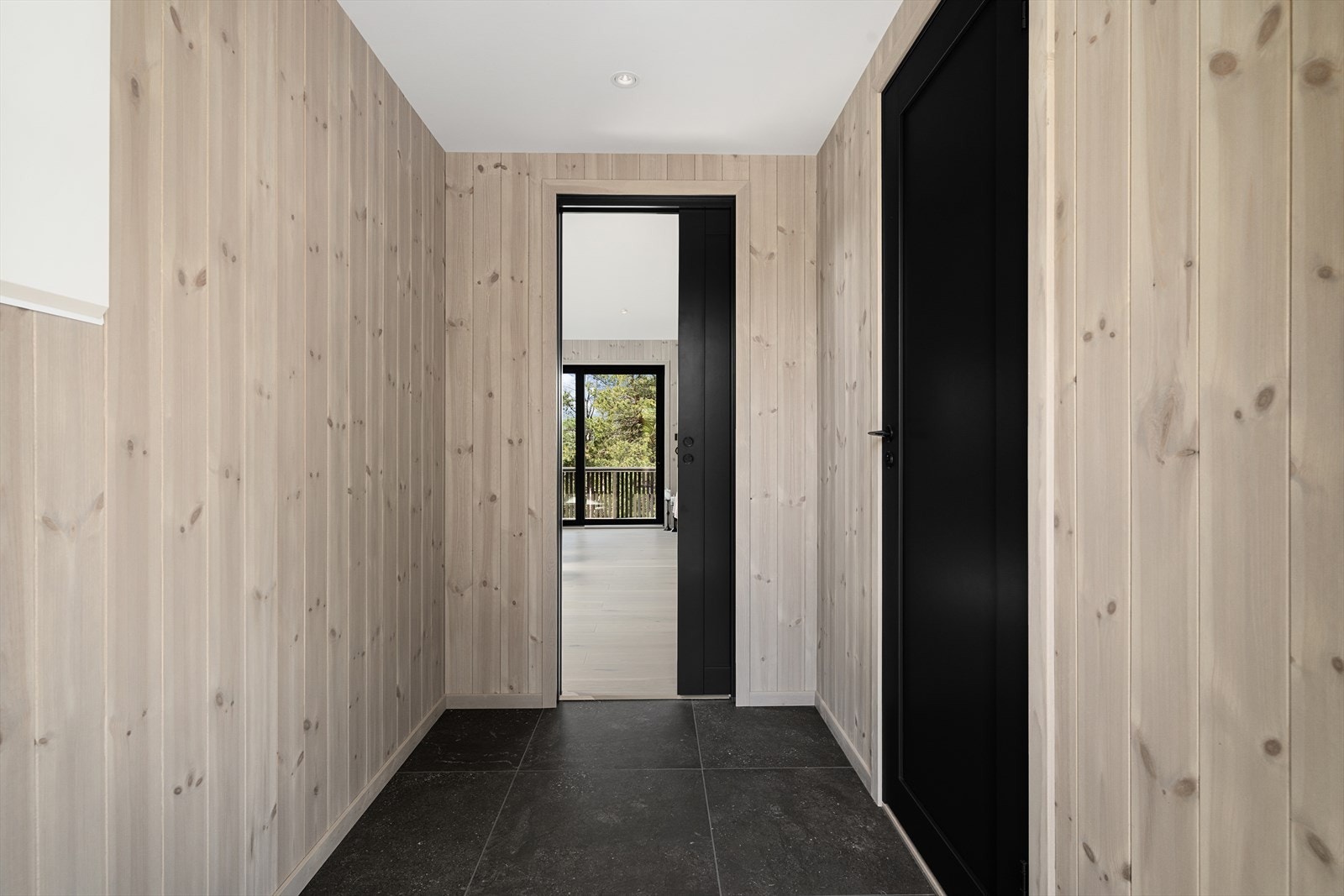 Entréen har flislagt gulv med varmekabler og vegger kledd med fabrikkbeiset trepanel. Galleribilde