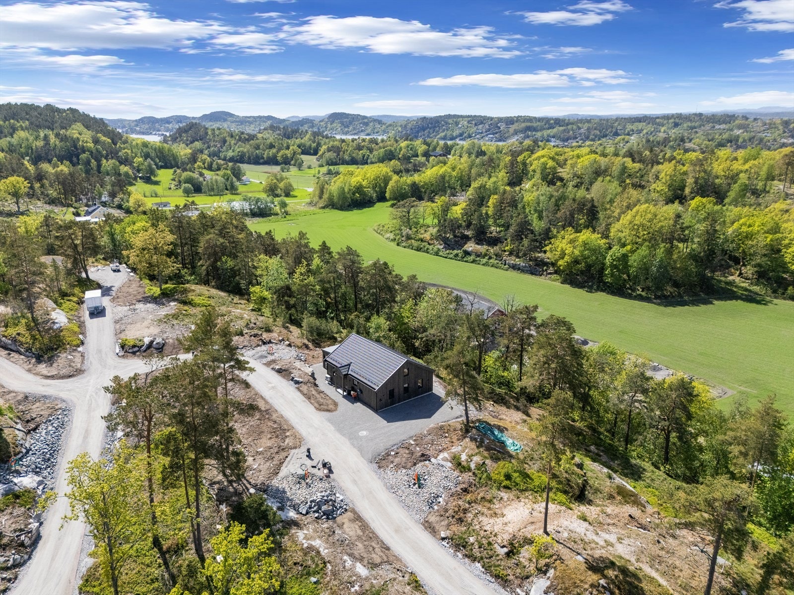 Tomten ligger høyt og fritt i terrenget. Galleribilde