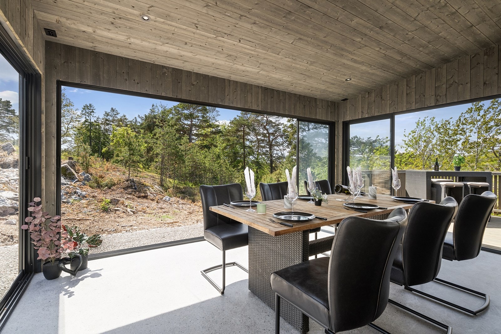 Skyvedører i glass og aluminium på tre vegger gir en panoramisk følelse og slipper naturen inn. Galleribilde