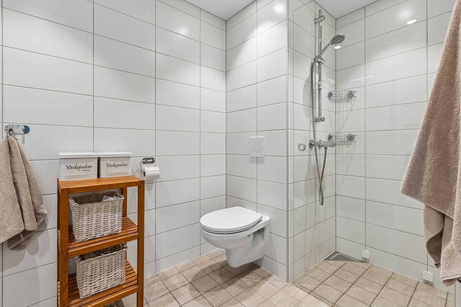 Dette badet har flislagt gulv med gulvvarme, vegghengt toalett og servantinnredning. Galleribilde