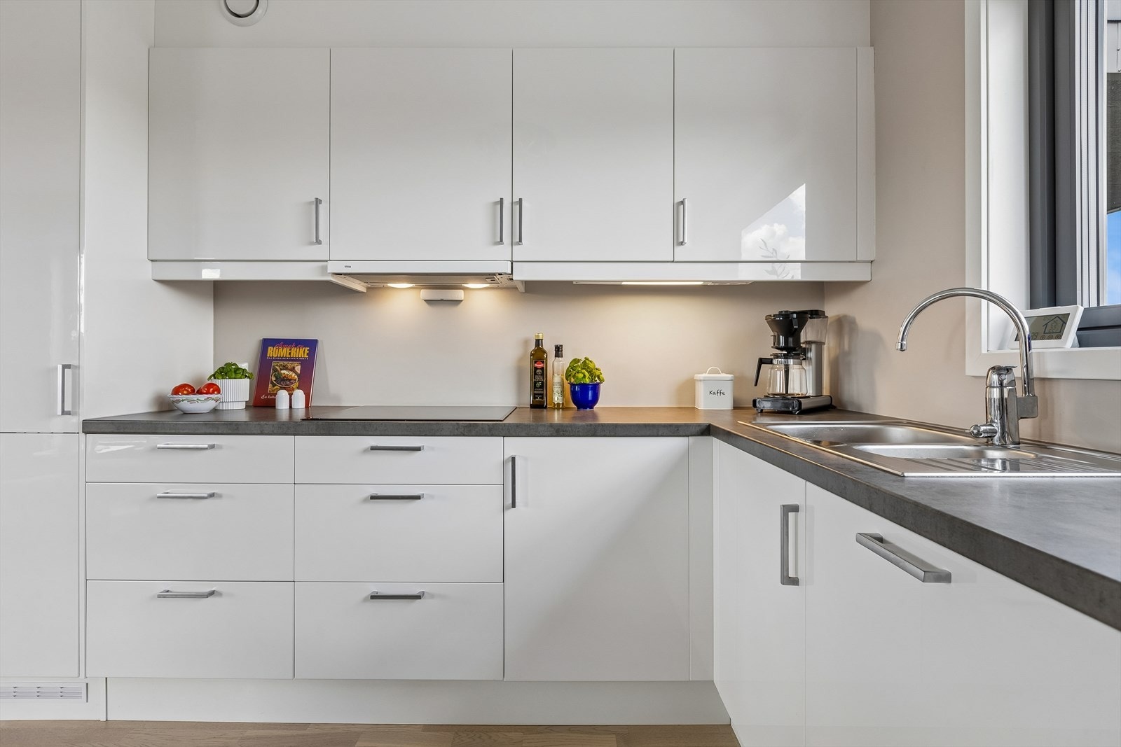 Kjøkkeninnredningen har glatte fronter og slitesterk laminatbenkeplate. Det er godt med arbeidslys fra belysning under overskapene. Galleribilde
