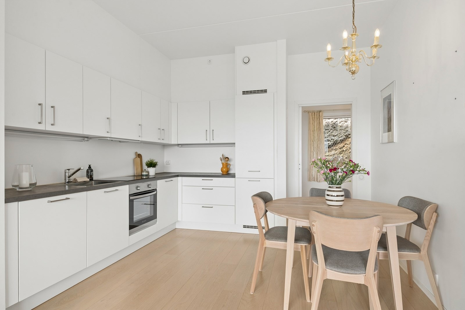 Kjøkkenet har en praktisk plassering i rommet, med vinklet innredning av slette fronter og laminatbenkeplate. Galleribilde