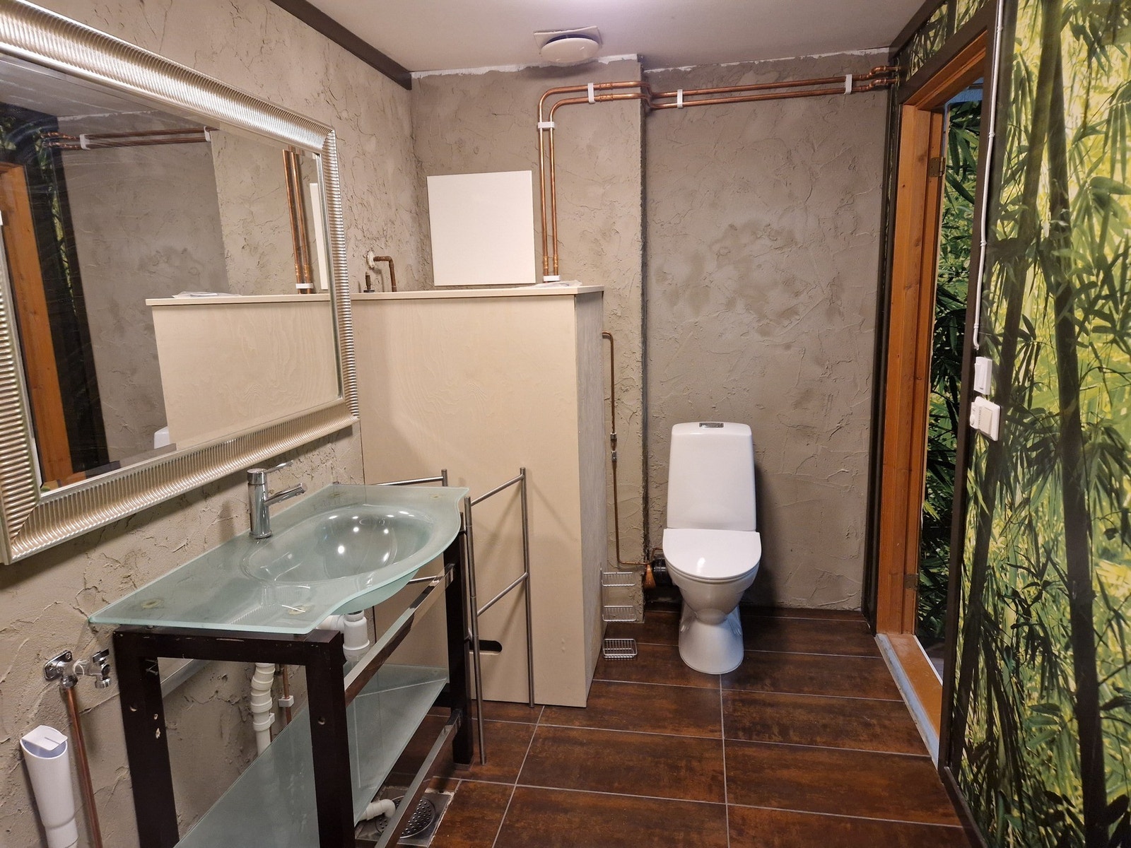 Badet i tilleggsdelen er utført med flislagt gulv med varmekabler og en kombinasjon av pusset og tapetsert vegg. Elektrisk vifte på vegg og luftespalte ved terskel. Galleribilde