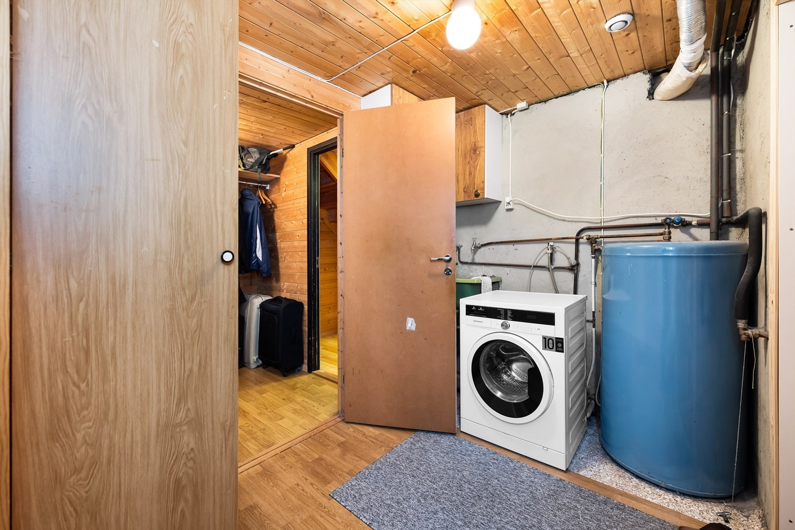 Vaskerommet er på nesten 7 kvm. Enkelt og praktisk innredet med skyllekar, plass for vask og tørk samt hyller og skap for oppbevaring. Det er også egen inngang fra uteområdet til vaskerommet. Galleribilde