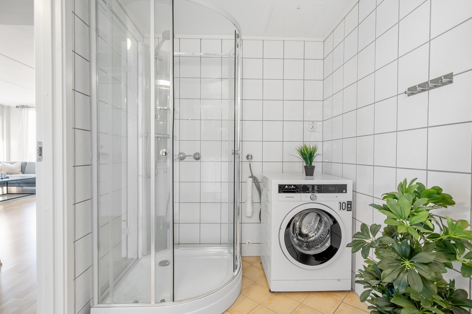 Badet er innredet med dusjkabinett, vaskemaskin, wc og baderomsservant Galleribilde