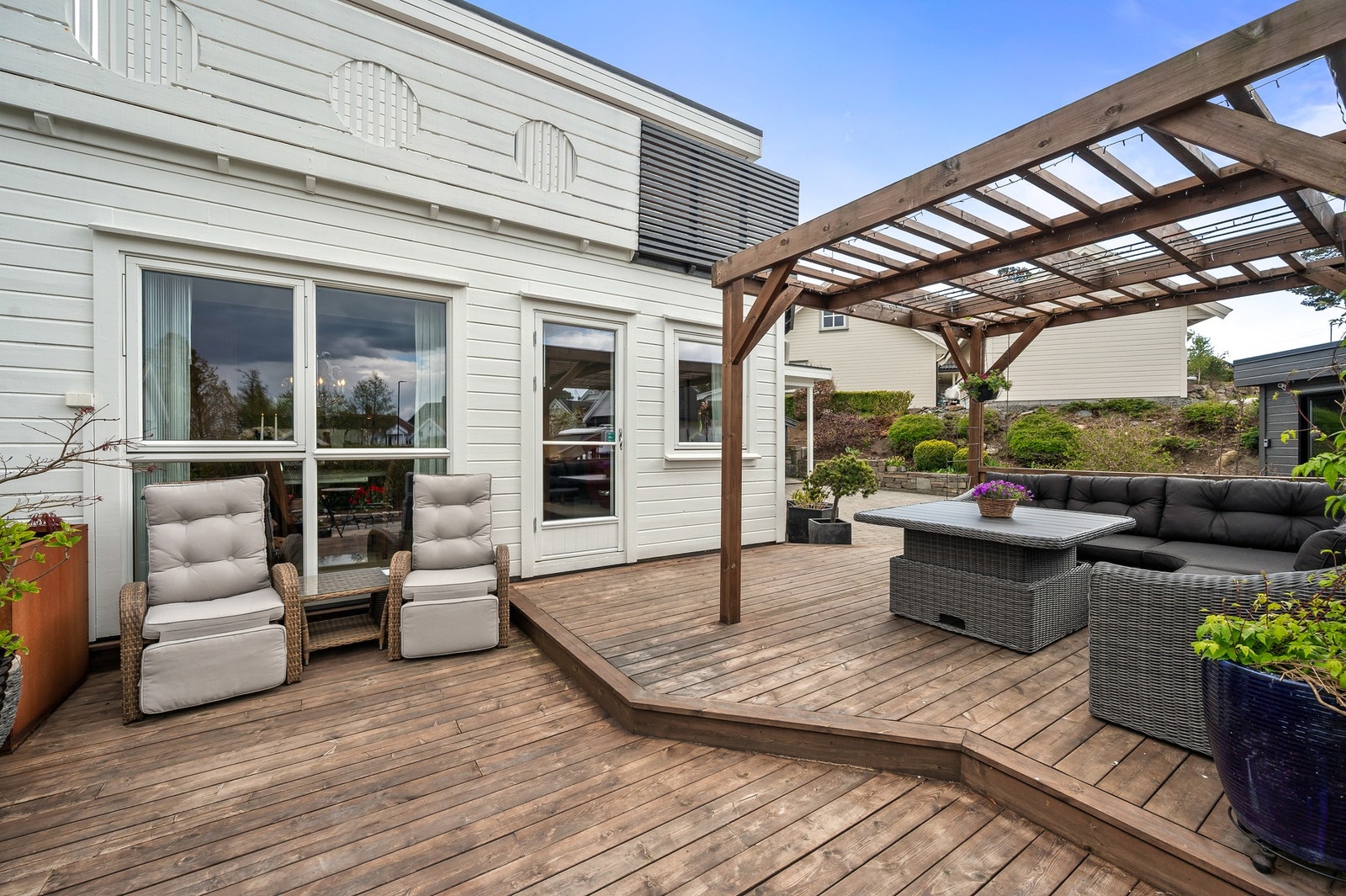 Den store terrassen danner et naturlig samlingspunkt på eiendommen med god plass til både loungegruppe, grill og hyggelige sammenkomster. Pergolaen skaper en skjermet atmosfære samtidig som den gir uteområdet et moderne uttrykk. Galleribilde