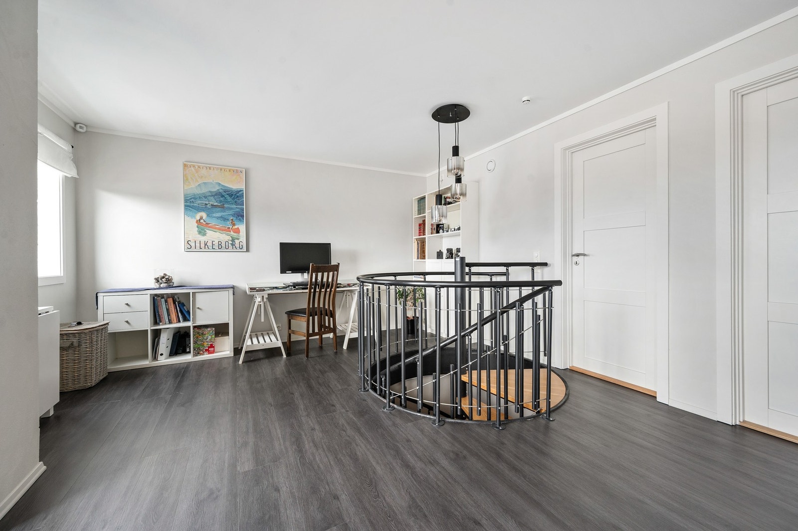 Loftstuen fremstår som et lyst og fleksibelt oppholdsrom med åpen løsning rundt vindeltrappen som gir en spennende arkitektonisk detalj og god romfølelse. Galleribilde