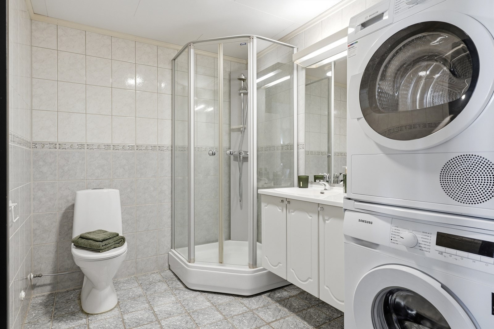 Badet er innredet med dusjkabinett, toalett og har opplegg for vaskemaskin. Galleribilde