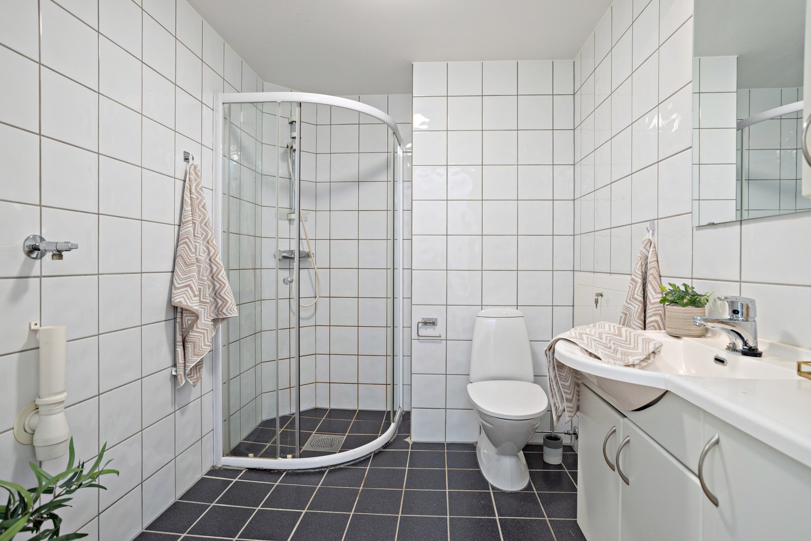Flislagt baderom med opplegg for vaskemaskin. Galleribilde
