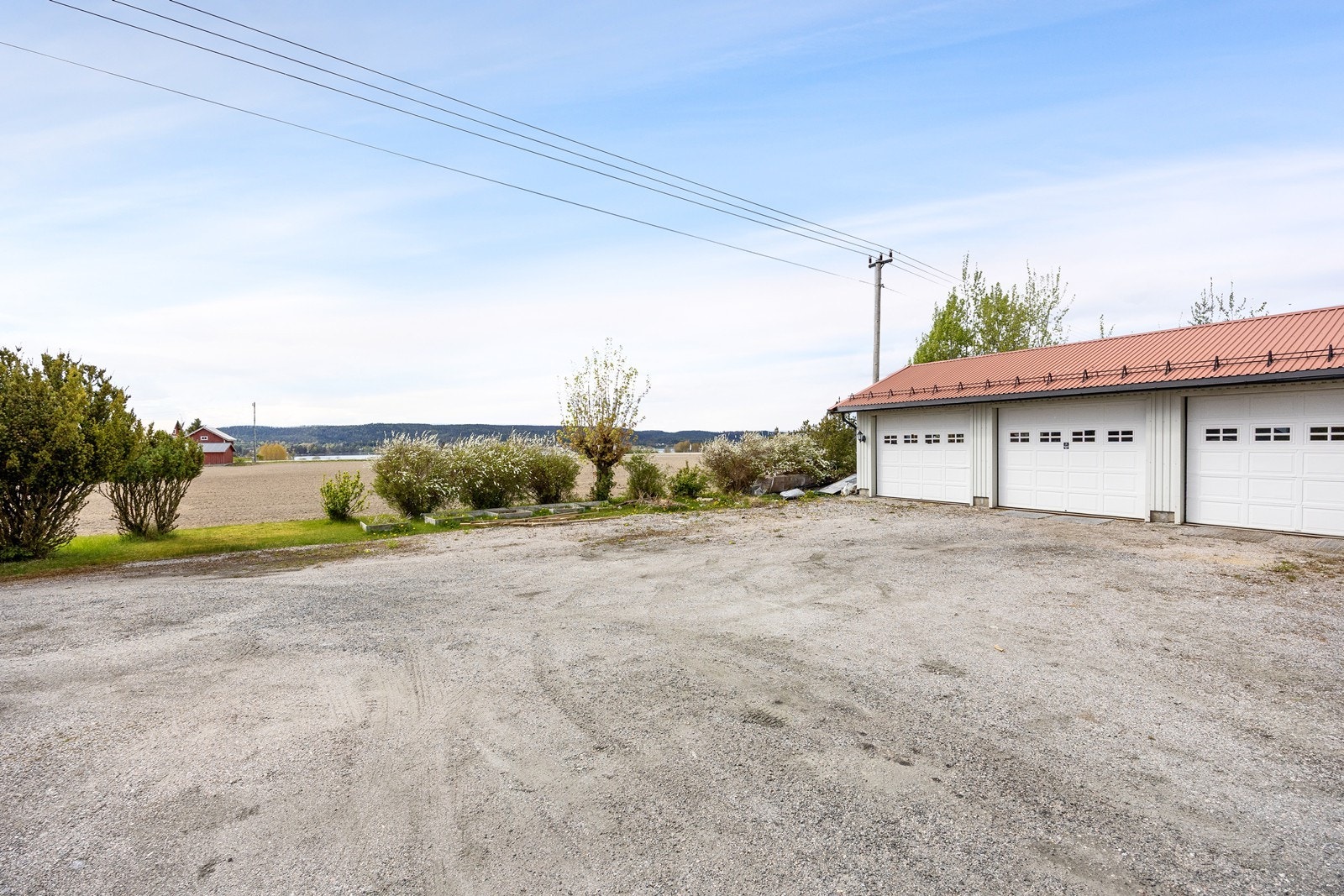 Det er plass til tre biler i den frittstående garasjen - som har hele tre leddporter, lagerrom og mulighet for verksted. Galleribilde