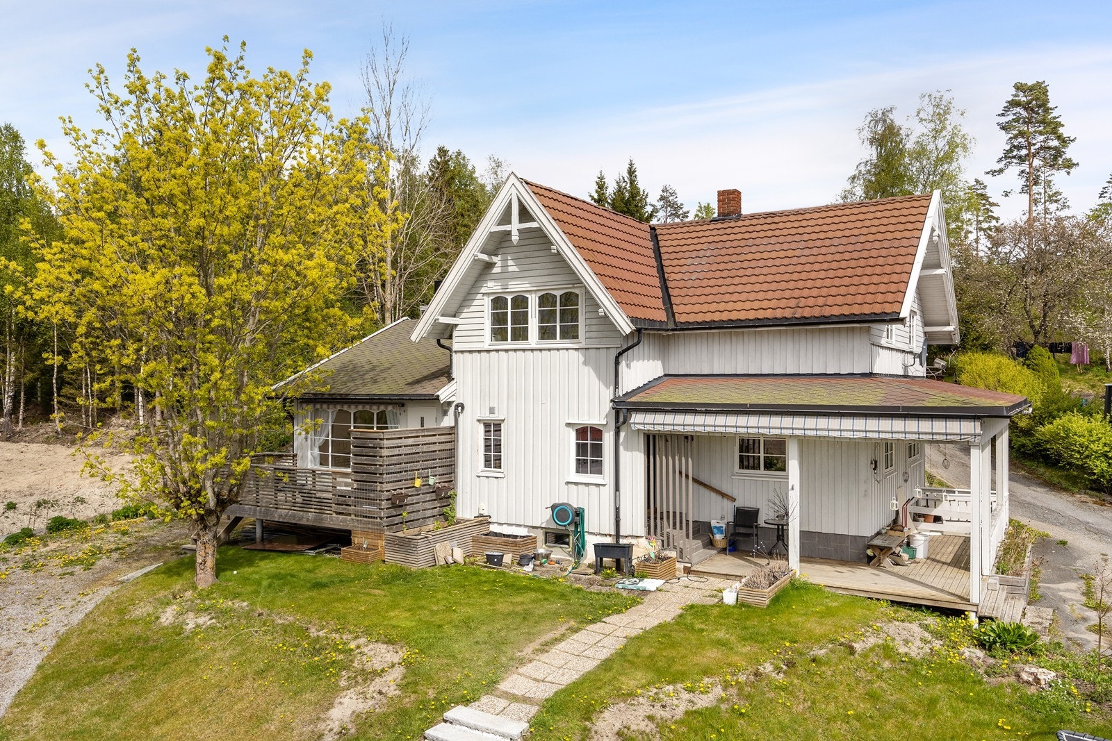 Tomten er opparbeidet med plenarealer, steinlagte områder og diverse beplantning. Galleribilde