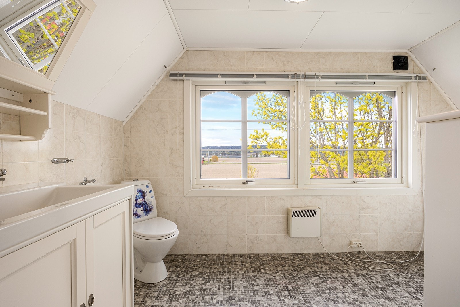 Badet i andre etasje ligger praktisk plassert ved soverommene. Innredningen består av en skapseksjon med heldekkende servant og speil med belysning. Galleribilde