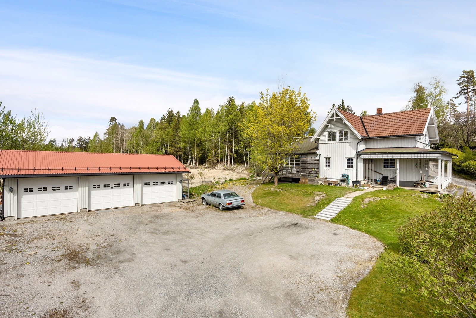 I tillegg til parkering i den frittstående garasjen, er det god plass også på den store gruslagte gårdsplassen. Galleribilde