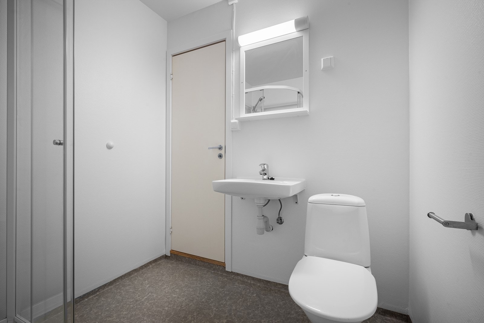 Badet er utstyrt med toalett, servant og dusjkabinett av nyere dato. Galleribilde
