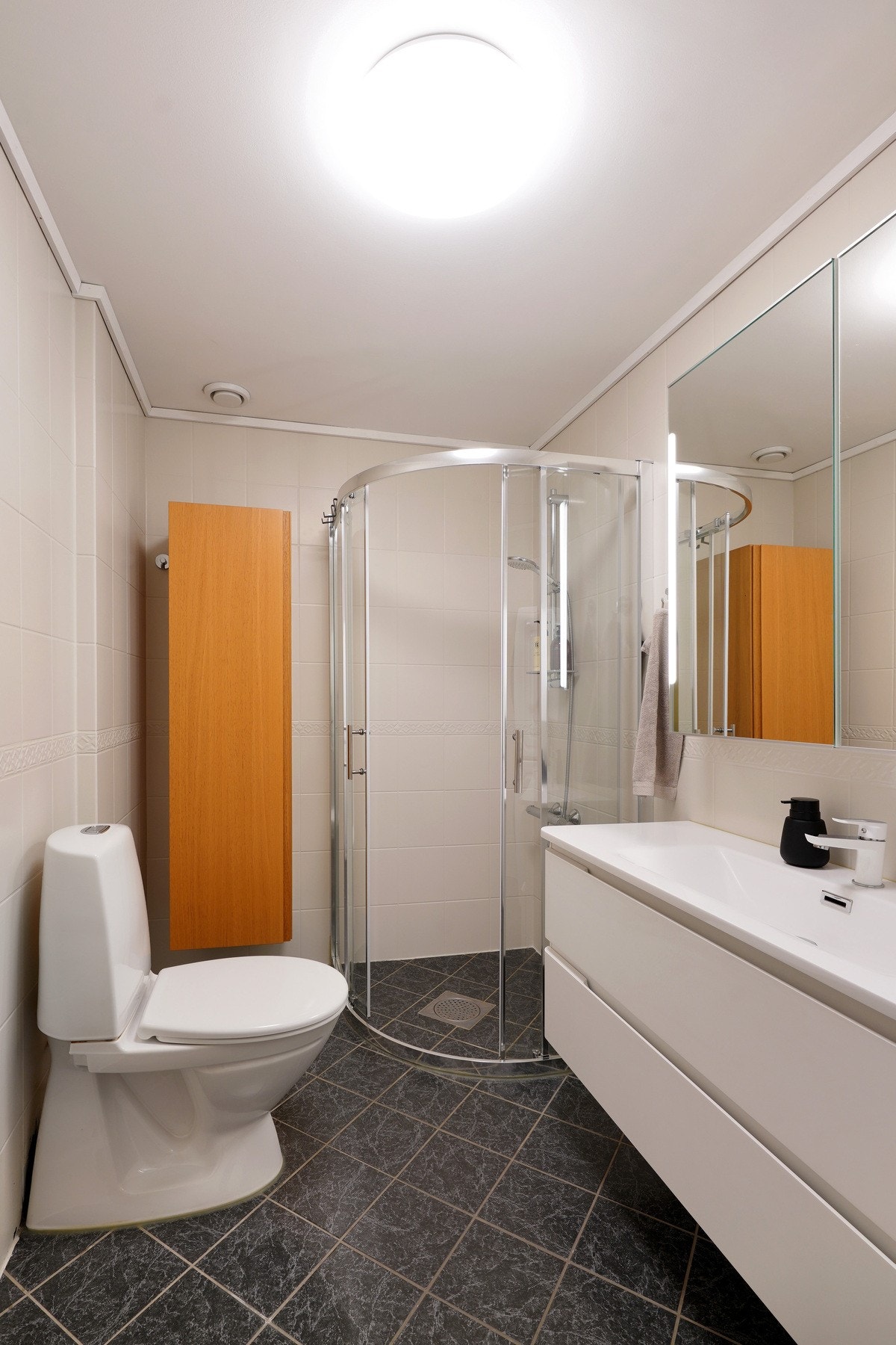 Badet har varme i gulv og masse praktisk oppbevaring. Galleribilde