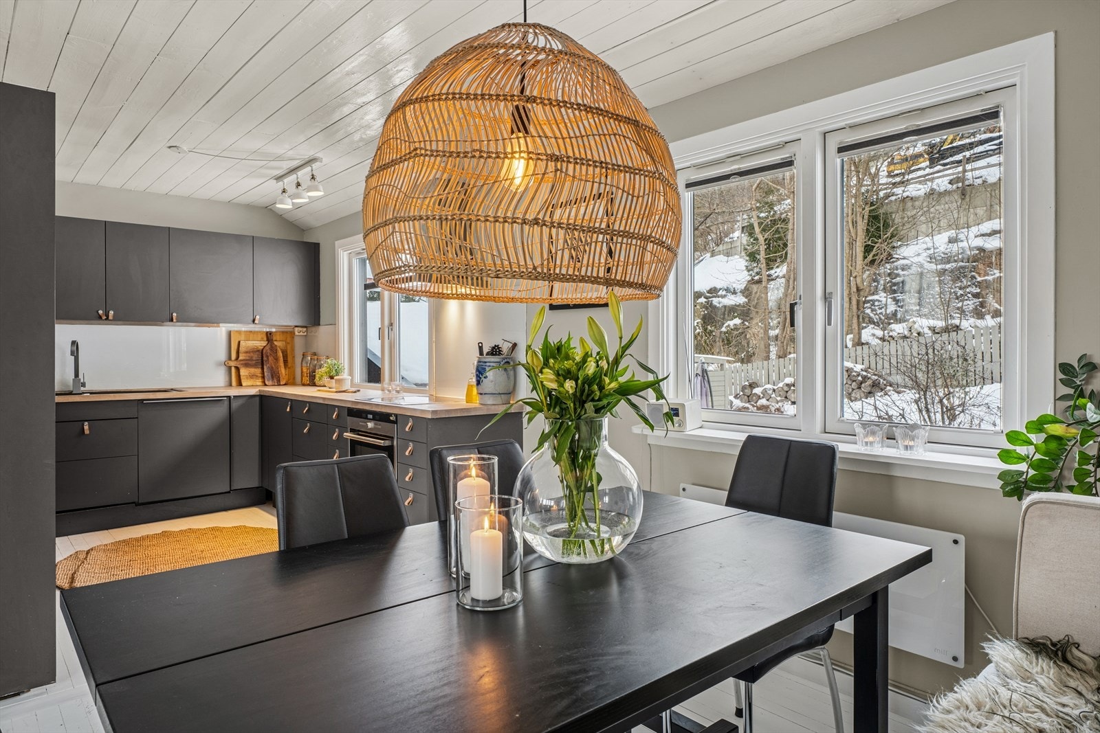Kjøkkeninnredningen har et moderne uttrykk med glatte fronter, benkeplate i heltre og nedfelt oppvaskkum i sort kompositt Galleribilde