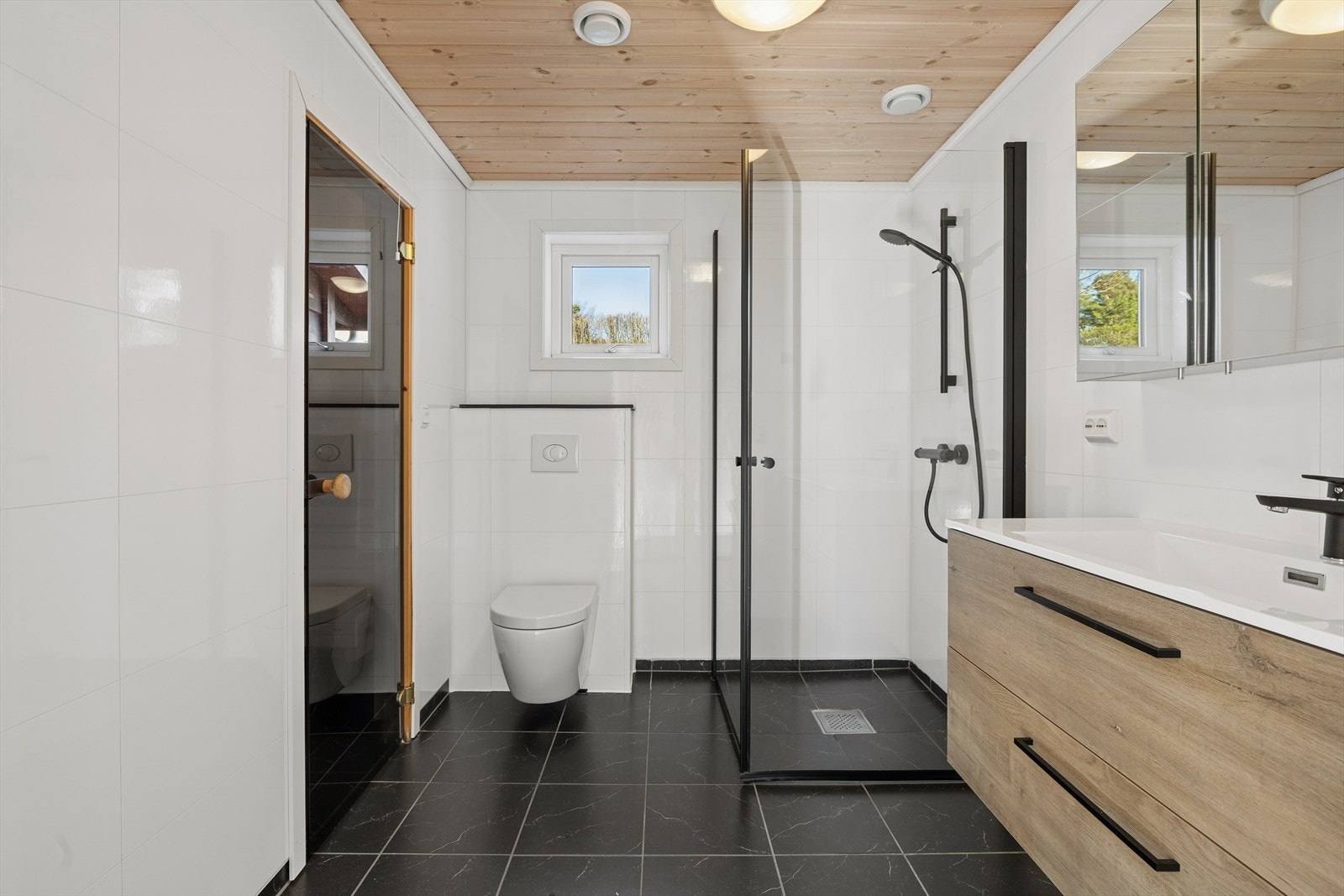 Pent baderom med vegghengt WC, dusjnisje og servant og badstue Galleribilde