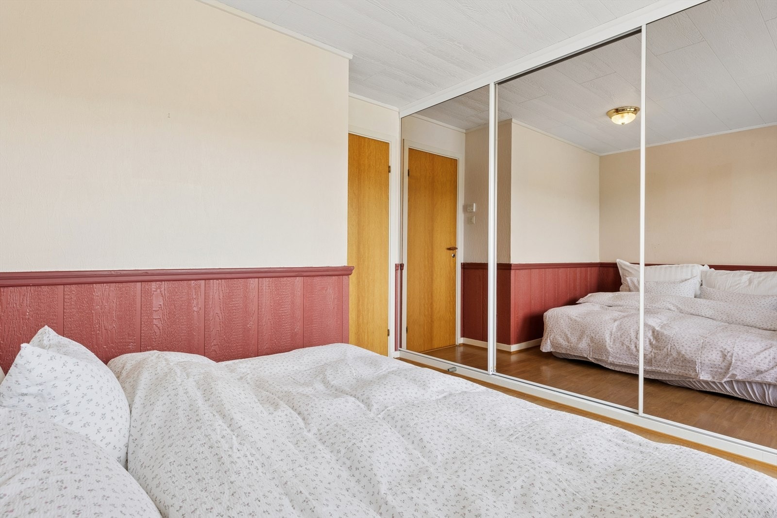 En stor skyvedørsgarderobe med speilfronter gir rikelig med oppbevaringsplass. Galleribilde