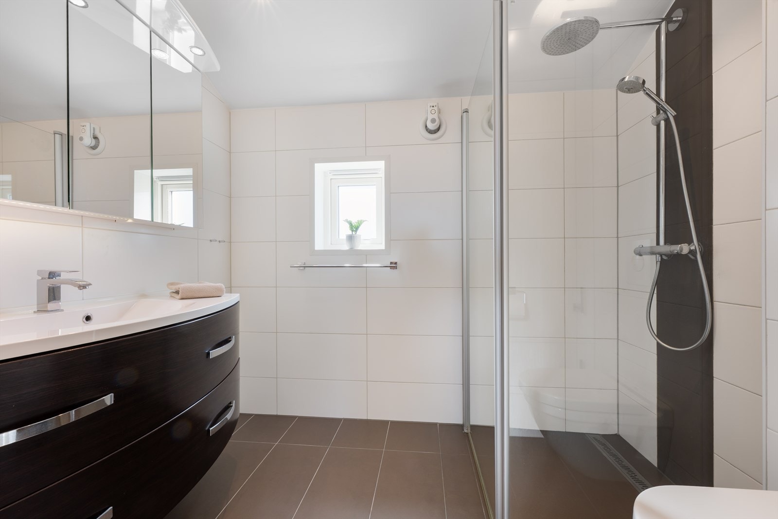 Badet er fra 2012 og er utstyrt med speil med oppbevaringsmuligheter, spotter i taket, god skuffeplass, dusj med linjesluk og rainshower, samt veggmontert toalett. Galleribilde